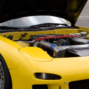 A closeup of a modern sports car with the hood popped open.